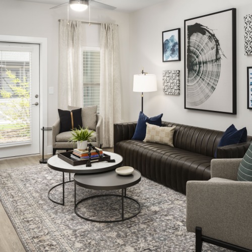 Modern, furnished living room with large windows at Arcadia at Symphony Park Apartments in McDonough, GA Modern, furnished living room with large windows at Arcadia at Symphony Park Apartments in McDonough, GA