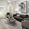 Modern, furnished living room with large windows at Arcadia at Symphony Park Apartments in McDonough, GA