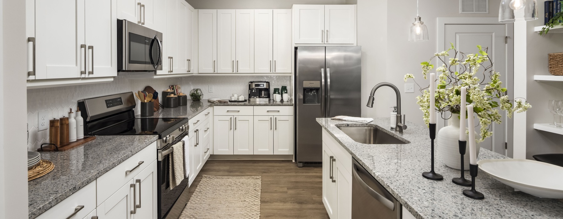 Kitchen with light cabinets, granite countertops and island at Arcadia Symphony Park Apartments for rent in McDonough