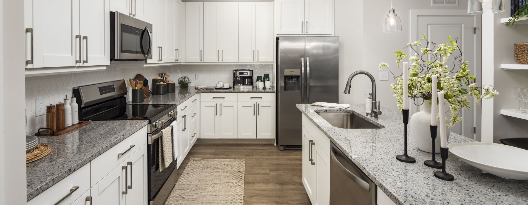 Kitchen with light cabinets, granite countertops and island at Arcadia Symphony Park Apartments for rent in McDonough